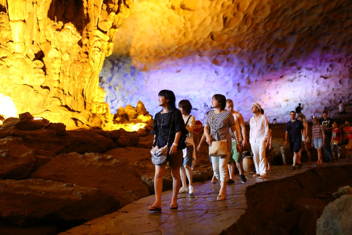 Tourists are walking on the small and narrow road which leads to the second part of Sung Sot cave